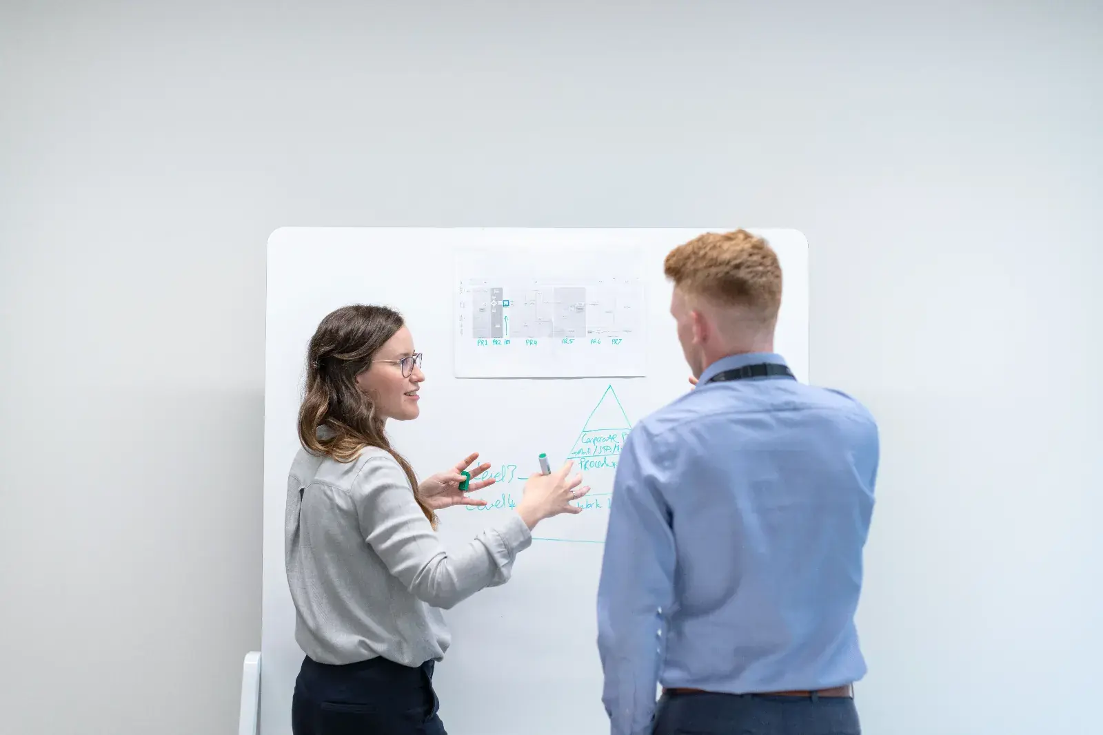 Development team comparing types of web application architecture on a whiteboard Development team comparing types of web application architecture on a whiteboard