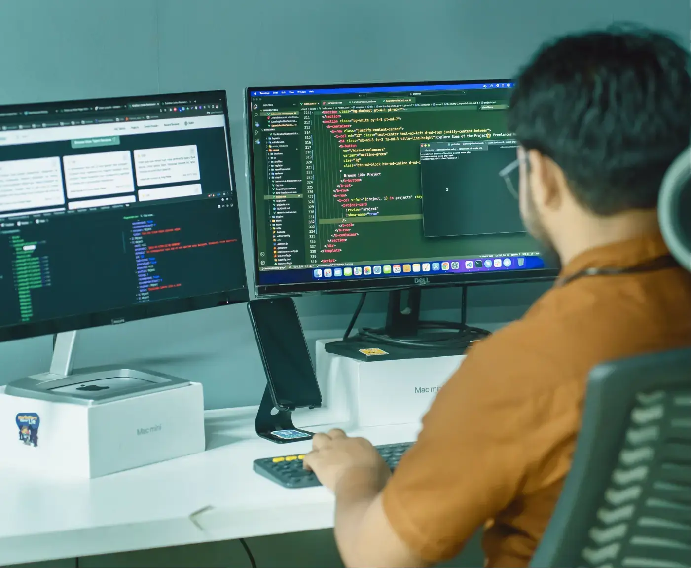 Team Engineer writing code on two monitors