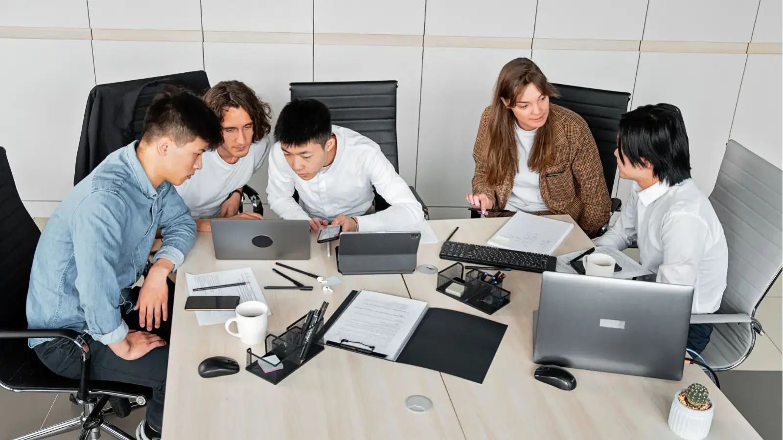 Build Custom Software Around Your Business Needs Business team collaborating on laptops around a table